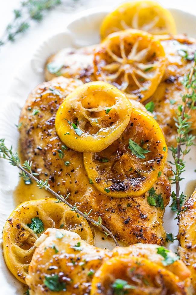 Grilled chicken breast with caramelized lemon slices and chopped parsley on a white plate.